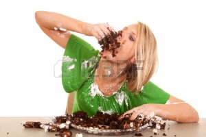 28112553-a-woman-stuffing-her-face-with-chocolate-cake--she-is-covered-all-over-in-frosting-and-cake